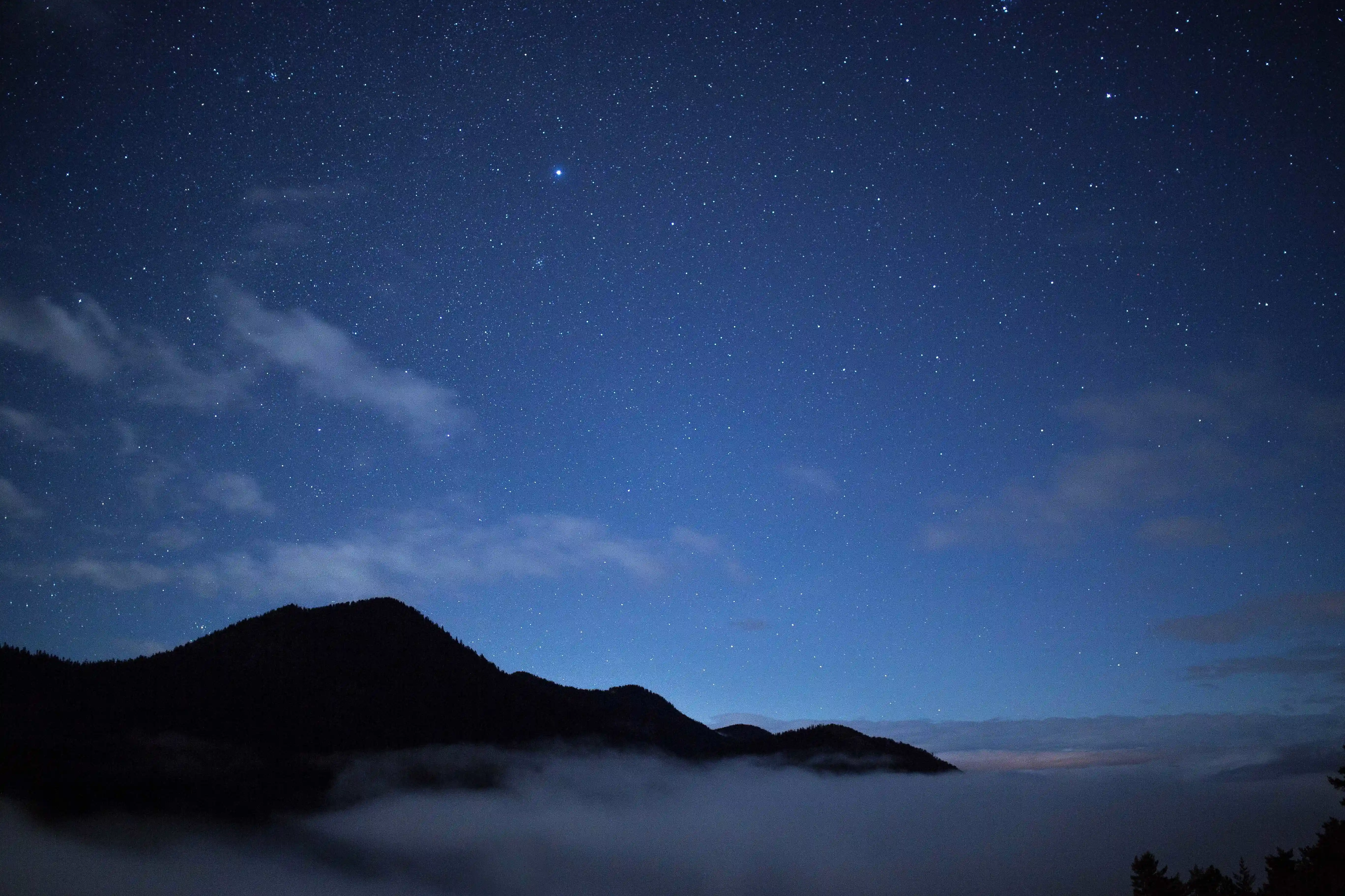 Atmosferisch nachtlandschap met zachte sterren en een warme gloed aan de horizon